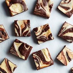 brownies with swirled icing are arranged on a white surface