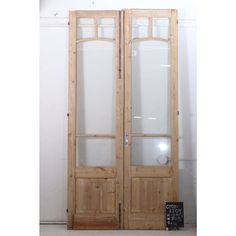 two wooden doors with frosted glass on the front and back sides, in an empty room