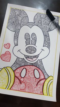 a drawing of mickey mouse on top of a piece of paper with marker pens next to it