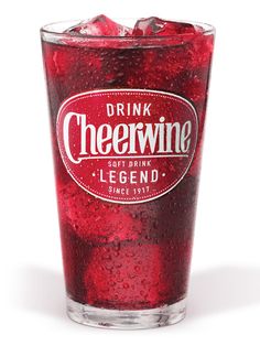 a glass filled with red liquid sitting on top of a table