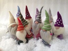 five gnomes are sitting in the snow with their heads turned to look like they're wearing hats