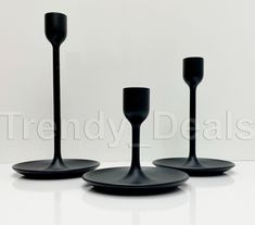 three black candlesticks sitting on top of each other