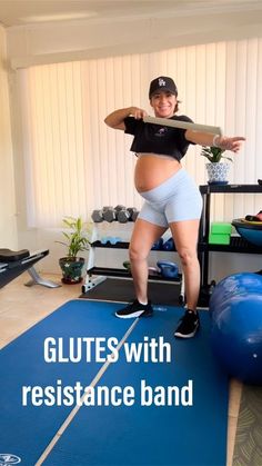 a pregnant woman standing on a blue exercise mat with the words glutes with resistance band