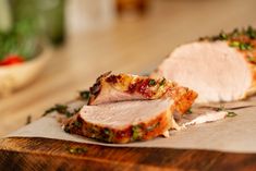 sliced meat sitting on top of a wooden cutting board