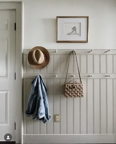 a hat, coat rack and purse hanging on the wall in front of a door