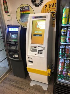 an atm machine sitting next to a vending machine filled with drinks and sodas