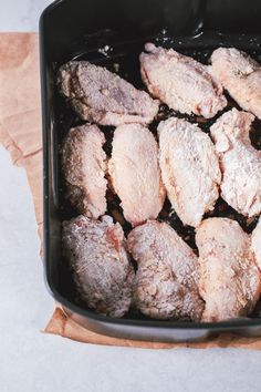 a pan filled with chicken and powdered sugar on top of a piece of paper