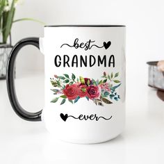 a white coffee mug with the words best granny ever printed on it and red flowers