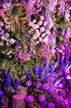 purple flowers and butterflies are arranged on the wall