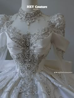 the back of a white wedding dress with silver sequins and beads on it