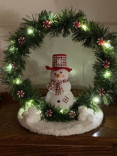 a christmas wreath with a snowman and candy canes in it on top of a table