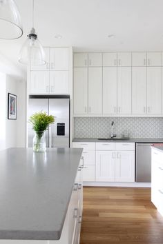 a kitchen with white cabinets and stainless steel appliances