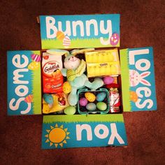 a box filled with lots of toys on top of a brown floor next to a sign that says, some bunny loves nook