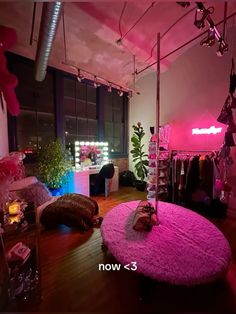 the room is decorated in pink and has clothes hanging from the ceiling, while other items are on display