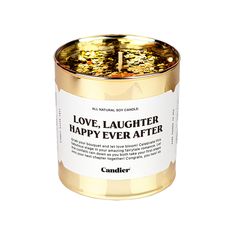 a candle that says love laughter, happy ever after on it's gold tin