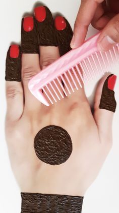 a hand holding a pink and brown comb