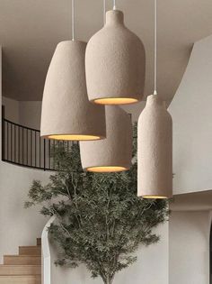 a bunch of lights hanging from the ceiling above a dining room table with chairs and a potted plant