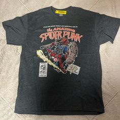 It’s A New Gildan Shirt And It’s Size Large. It Has The Amazing Spider Punk Graphic On The Front And It’s Dark Gray In Color Punk Style Graphic Fan Merchandise Top, Punk Graphic Design Top For Fan Merchandise, Punk Style Crew Neck Shirt With Graphic Print, Casual Shirt With Screen Print For Alternative Fashion, Casual Graphic Design Shirt For Conventions, Cotton Tops With Character Print For Alternative Fashion, Edgy Cotton Tops With Character Print, Punk Style Cotton Shirt With Graphic Design, Casual Shirt With Letter Print For Fan Conventions