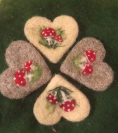 four heart shaped felt pieces with red and white mushrooms on them