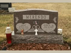 a headstone with two hearts on it and a cup next to it in the grass