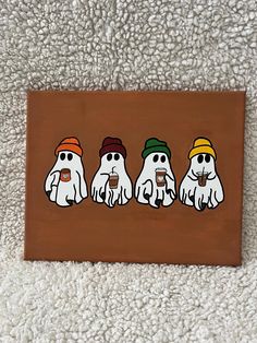 three ghostes are sitting in a row on a brown background, one is holding a cup and the other has a green hat