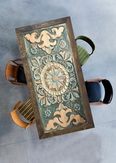 an overhead view of a dining table with chairs and a painting on the wall above it