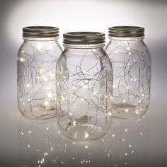 three mason jars with fairy lights in them