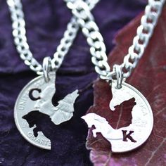 two silver necklaces with the letter k and an image of a bat on them