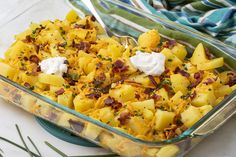 a casserole dish with potatoes, bacon and sour cream