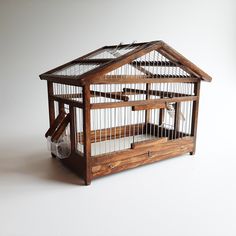 a wooden bird cage with two birds inside