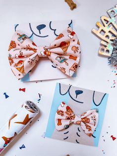 two bow ties are laying next to each other on a white table with confetti