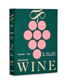 a wine book with pink grapes on the front and green cover, sitting on a white surface