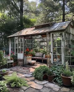 a small greenhouse with lots of potted plants and flowers in the front yard area