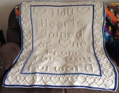 a white crocheted afghan with words written on it, sitting on a couch