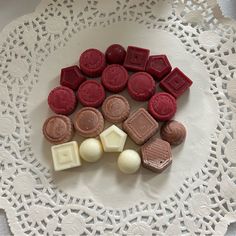 several different types of chocolates on a white doily with lacy doily around them