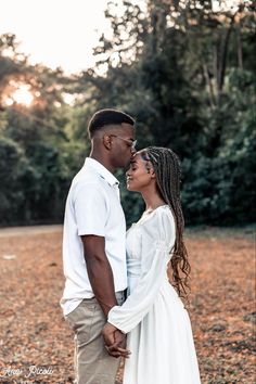 a man and woman are standing together in the grass