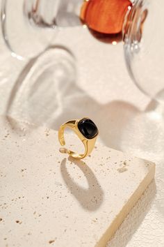 A symbol of protection and quiet confidence, the "Nocturne" Black Onyx Square Ring carries the strength of the night within its bold design. The natural black onyx, known for grounding energy and shielding its wearer from negativity, sits at the heart of this striking piece. Encased in 18k Gold Vermeil over sterling silver, its clean, angular lines speak to modern elegance, while the deep, lustrous stone evokes a sense of mystery and resilience. Materials: Natural black onyx, framed in 18k Gold Modern Black Tarnish-resistant Signet Ring, Modern Black Tarnish Resistant Signet Ring, Black Crystal Gemstone Ring For Gift, Black Crystal Ring With Gemstone For Gift, Minimalist Adjustable Black Rings, Minimalist Black Tarnish Resistant Rings, Adjustable Black Signet Ring With Polished Finish, Minimalist Black Tarnish-resistant Rings, Adjustable Black Minimalist Signet Ring