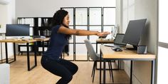 a woman is standing on one leg in front of a desk with a monitor and keyboard