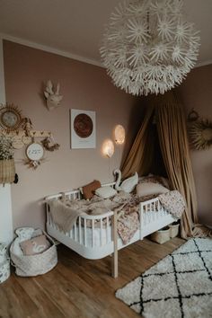 a baby's room with a crib, bed, and chandelier