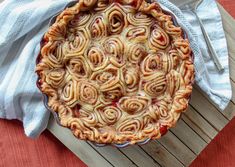 a pie sitting on top of a wooden table next to a white napkin and fork