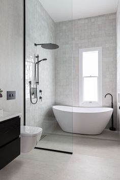 a white bathtub sitting next to a window in a bathroom