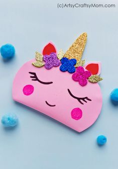 a pink unicorn shaped bag with gold glitters on it's head and eyes