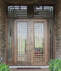 a large wooden door with metal bars on the top and side panels, in front of a brick building