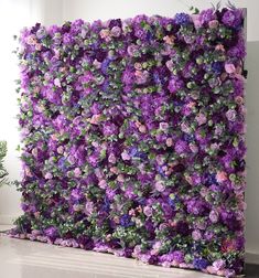 purple flowers are growing on the side of a wall in an office building with white walls