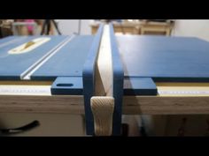 a close up of a table sawing with a blue board on it's side