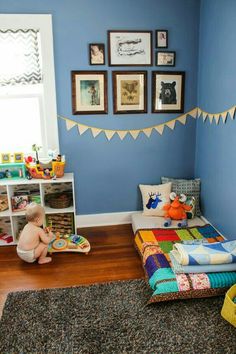 a child's bedroom with blue walls and pictures on the wall