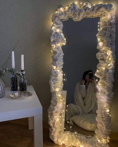 a woman taking a selfie in front of a mirror with lights on the sides