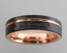 a rose gold wedding band with black and white wood inlay