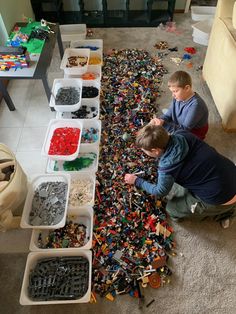 two boys are playing with legos on the floor