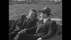 a man and woman are sitting in a boat on the water, looking at each other